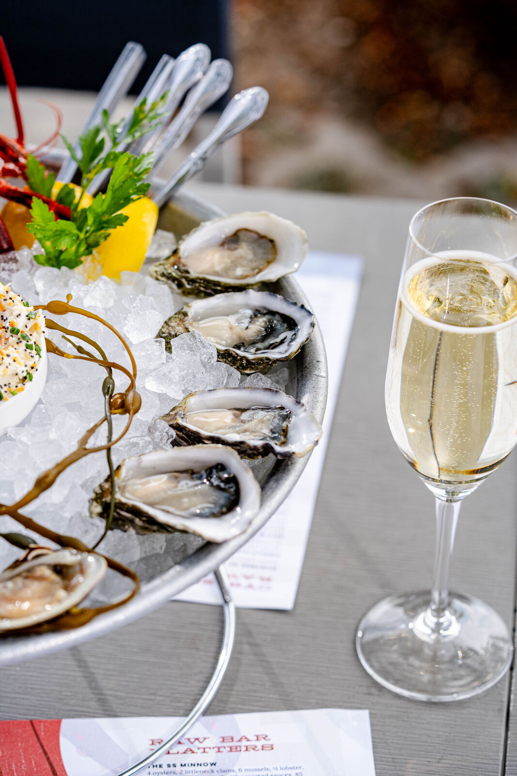 A platter of freshly shucked oysters beside a glass of champagne